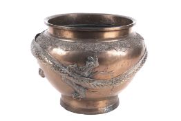 A Chinese metal jardinere with a headless writhing dragon in relief around the body.