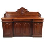 A Victorian mahogany inverted breakfront sideboard with carved crest.