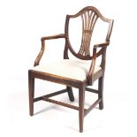 An early 20th century mahogany armchair with shield back and upholstered seat. H95cm.