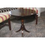 A 20th century mahogany small drop flap circular table. Four legs. 56cm H and 61cm diameter.