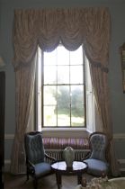 A pair of damask silk lined curtains and matching tasselled pelmet.