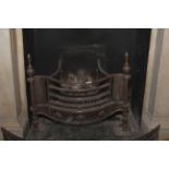 A Regency manner serpentine shaped cast iron and steel fire basket. Flanked with turned finials, 66.