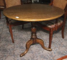 A Georgian oak circular tilt top pedestal table. 75cm H x 87cm diameter.