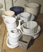 An assortment of mostly white glazed jelly moulds, bowls, jars,