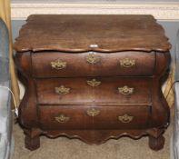 A 19th century Continental oak bombe shaped chest of drawers with three drawers.