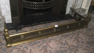 An Edwardian brass fire fender.