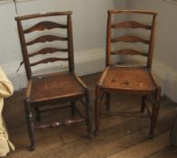 A pair of East Anglian 18th century ladder back solid seat oak chairs. Each 91cm H, 46cm W, 35cm D.