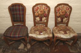A collection of three French cabriole dining chairs with over stuffed seats and upholstered backs