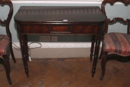 A George IV mahogany fold over tea table. Turned legs and one hinged versa, 75cm H, 92cm W, 88cm D.