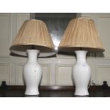 A pair of Kandella table lamps. With white ceramic bases and pleated silk shades, 65cm H.