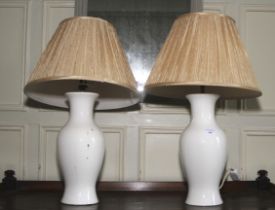 A pair of Kandella table lamps. With white ceramic bases and pleated silk shades, 65cm H.