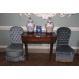 A pair of early 20th century style, blue velvet button back boudoir chairs.