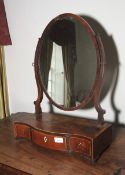 A late 18th century flame mahogany oval toilet/swing mirror, 62cm H, 45cm W, 21cm D,