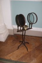 A 19th century candle magnifier on a guadreped stand. Constructed of cast metal and brass.