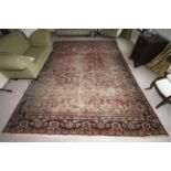 A large Persian woollen rug, 382cm x 272cm, with red ground with blues,