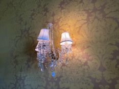 A pair of ormolou and cut glass three branch wall lights with facets and lustre drop decoration