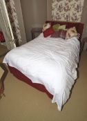 A red upholstered herringbone headboard, bed frame with space under, nine cushions, pillows etc.