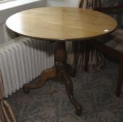 A Georgian oak tripod tilt top table. 71cm H x 87cm diameter.