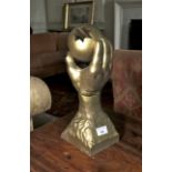 Reproduction of a gilt sphere held by a hand. 35cm H.