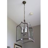 A contemporary three branch patternated met-al and four glass lancet shaped hall lantern