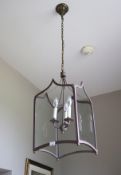 A contemporary three branch patternated met-al and four glass lancet shaped hall lantern