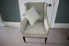 An Edwardian upholstered wing back, brackets with ears, armchair,