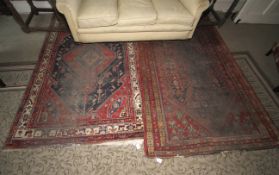 Two rugs to include a Persian red ground rug, 244cm x 144cm, with yellow, blue,