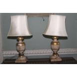 A pair of gilt and flecked turned table lamps. 75cm H, with shaped shades.