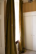 A pair of lined green velvet curtains.
