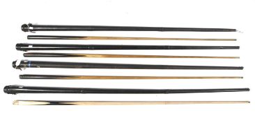 A collection of four snooker cues.