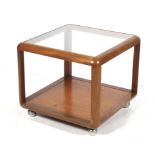 A mid-century teak and glass top coffee table. With a shelf beneath on chrome feet.