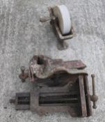 Two vintage bench vices and a sharpening stone wheel.