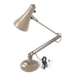 An angelpoise desk lamp with circular base.