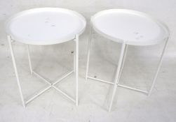 A pair of Ikea Gladom white metal bedside circular tables.