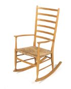 A mid-century ladderback rocking chair with rattan seat.