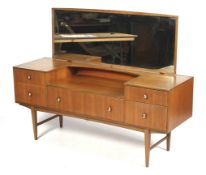 A mid-century retro teak dressing table with mirror. With five drawers, on square tapering supports.