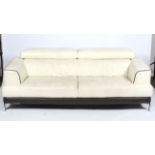 A contemporary cream leather three seater sofa.