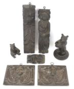 An assortment of wooden carvings. Including a pipe stand modelled as a bear, two wall plaques, etc.