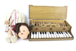 A vintage walking doll and a toy piano.