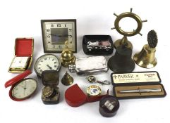 An assortment of collectables. Including an ashtray, clocks, a brass bell, glass bottles, etc.