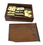 A set of twenty-eight vintage bone dominoes. Within a wooden box, L16.