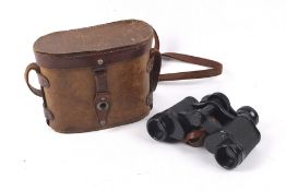 A pair of military Kraytor 8x binoculars. In a brown leather case with shoulder strap.