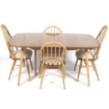 A mid-century light oak Ercol rectangular extending dining table and four chairs.