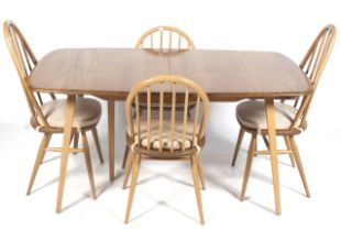 A mid-century light oak Ercol rectangular extending dining table and four chairs.