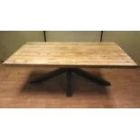 A large contemporary wooden dining table with metal base.