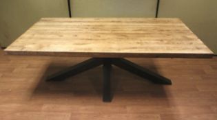 A large contemporary wooden dining table with metal base.