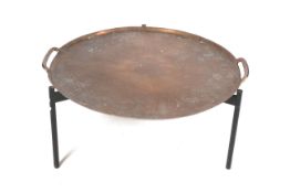 A large 'paella dish' style coffee table. On a tripod support.