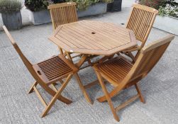 A modern five piece suite of teak folding garden furniture.