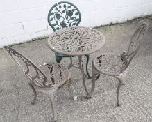 A set of cast metal garden furniture. Including a circular table and three chairs.