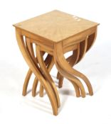 A contemporary nest of three occasional tables. On curved tapering supports. Max.